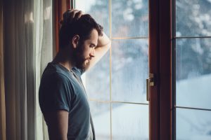depressed man looking out the window