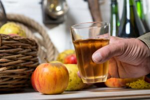 man holds glass of apple cider