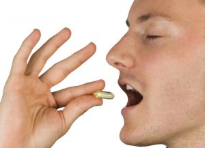 man taking fish oil supplement