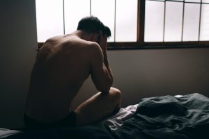 depressed naked man in bed