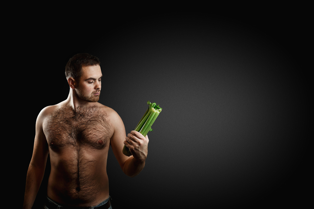 shirtless hairy man holding celery