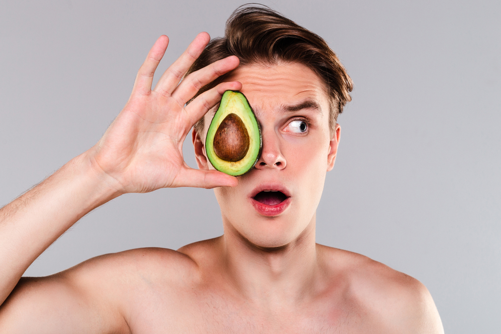 man holding up an avocado