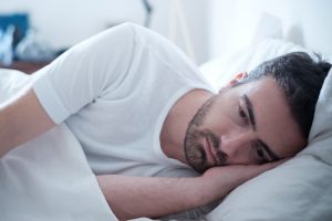 depressed man lying in bed