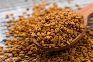 fenugreek seeds on wooden spoon