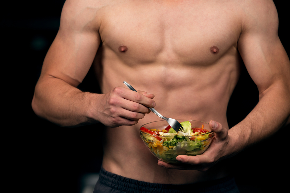 fit man eating fresh salad