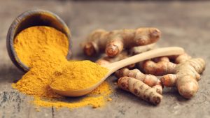 turmeric roots and powder in spoon