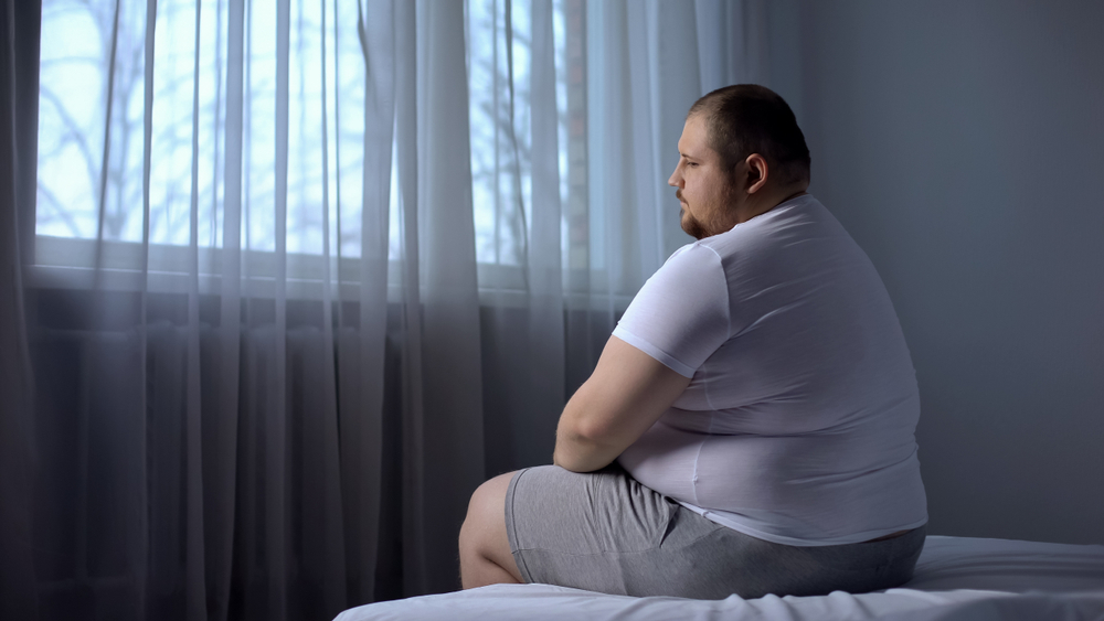 depressed obese man in bed