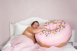 obese man sleeping with donut