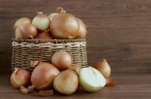 raw white onions in a basket