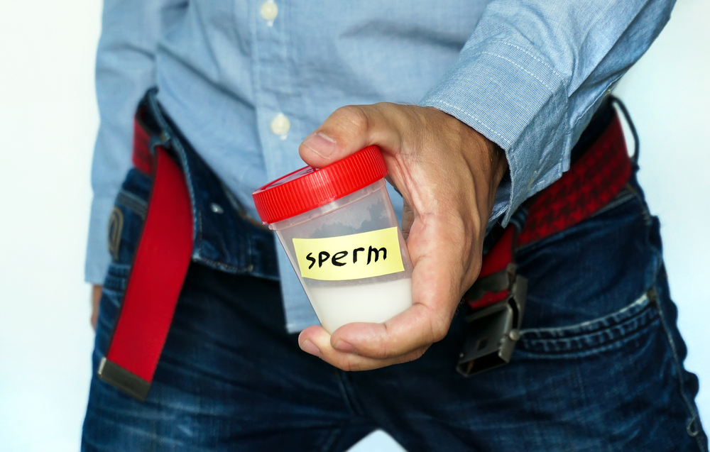 man holds container with sperm