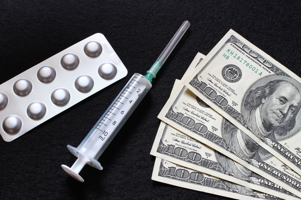 syringe, pills, and dollars