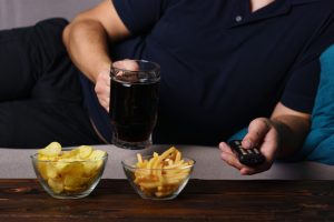 couch potato with junk food and soda