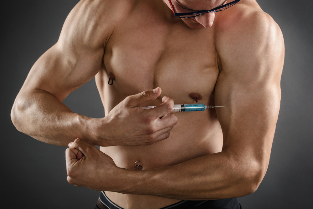 muscular guy injecting his arm