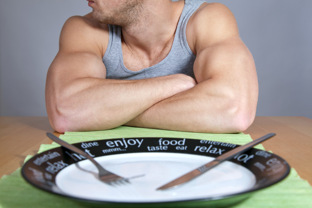 muscular man ignores empty plate