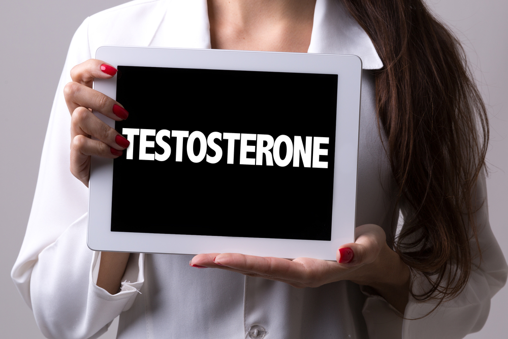woman holds testosterone sign