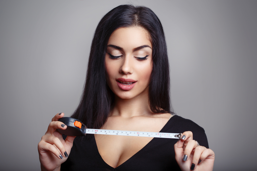 woman holding up tape measure on penis size