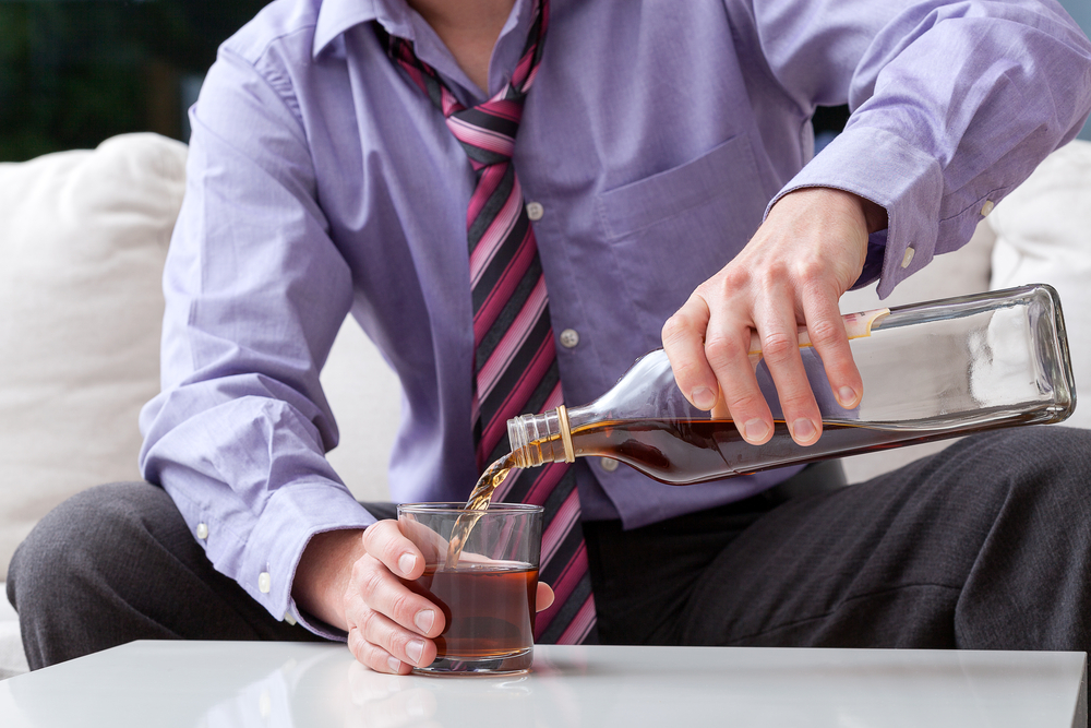 alcoholic man pouring brandy