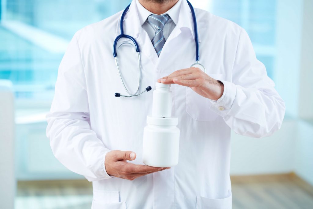 doctor holding pill bottles
