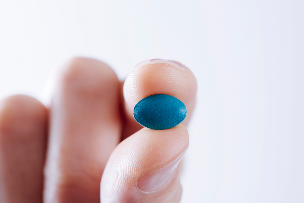 holding blue viagra pill