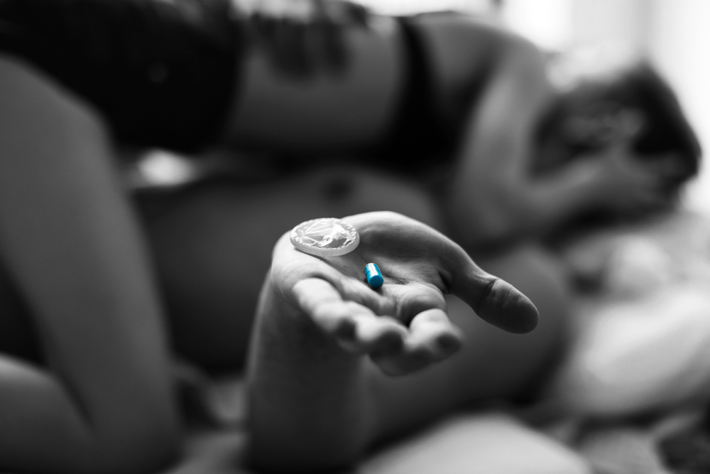 man holding blue pill during sex