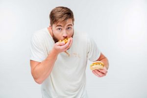 young bearded man eating fastfood