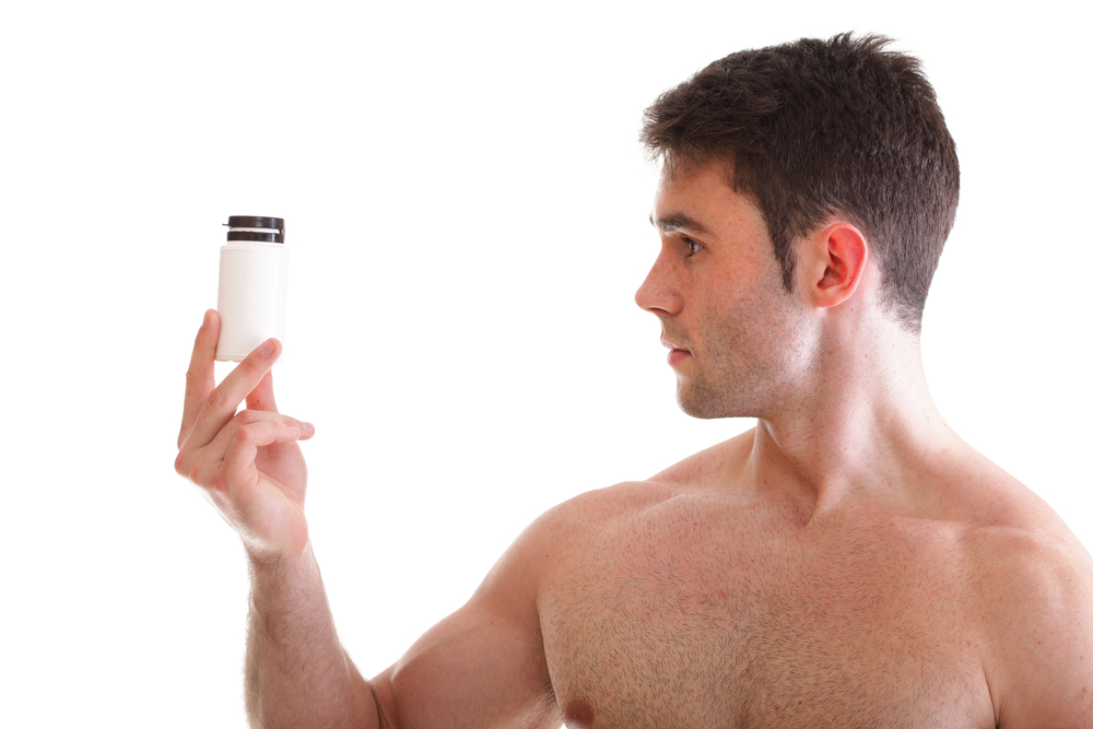 inspecting male enhancement pill bottle