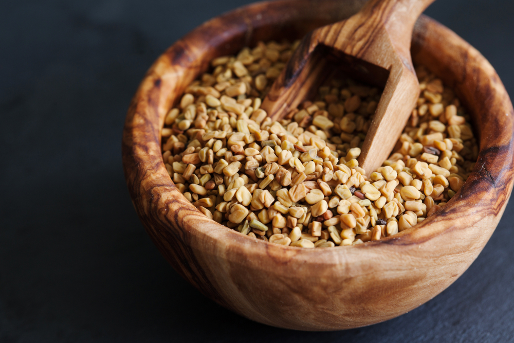 fenugreek seeds in wooden bowl