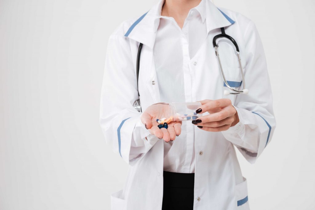 female doctor holding male supplement pills