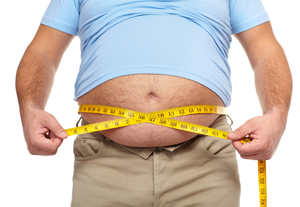 obese man measures belly