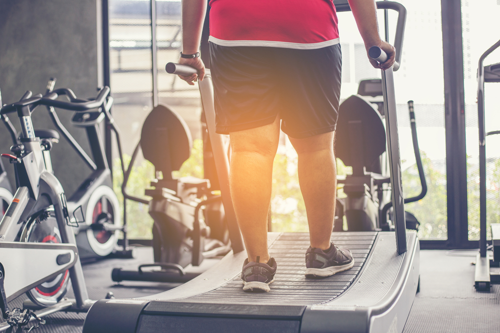 overweight man exercising on treadmill