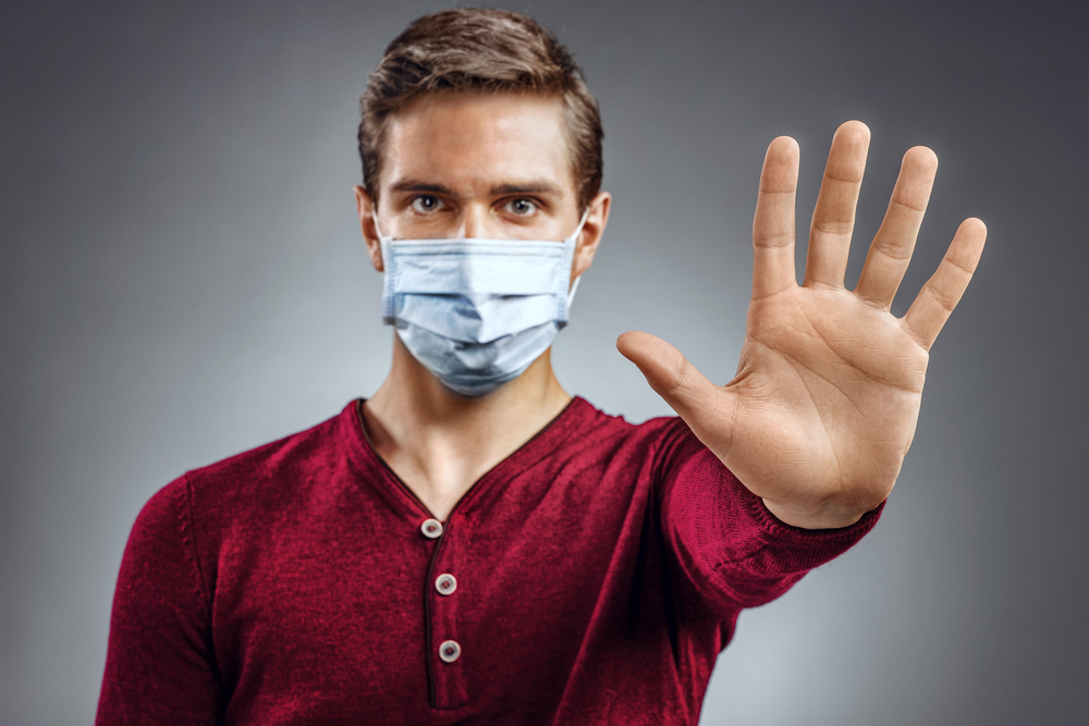 man with surgical mask stop hand sign