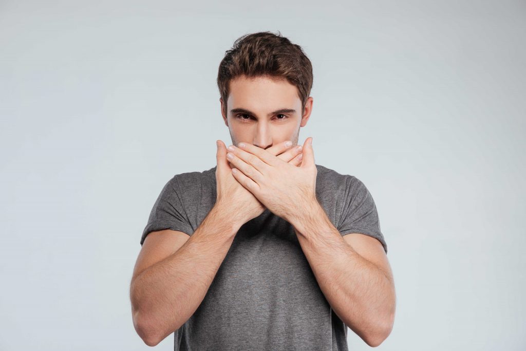 man covers mouth with both hands