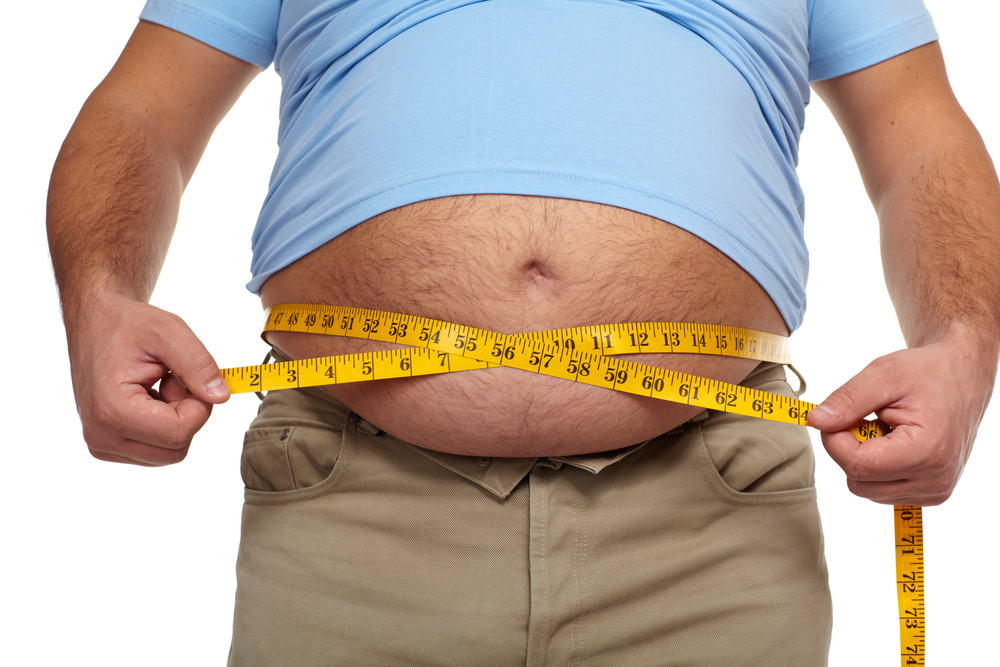 obese man measures waist