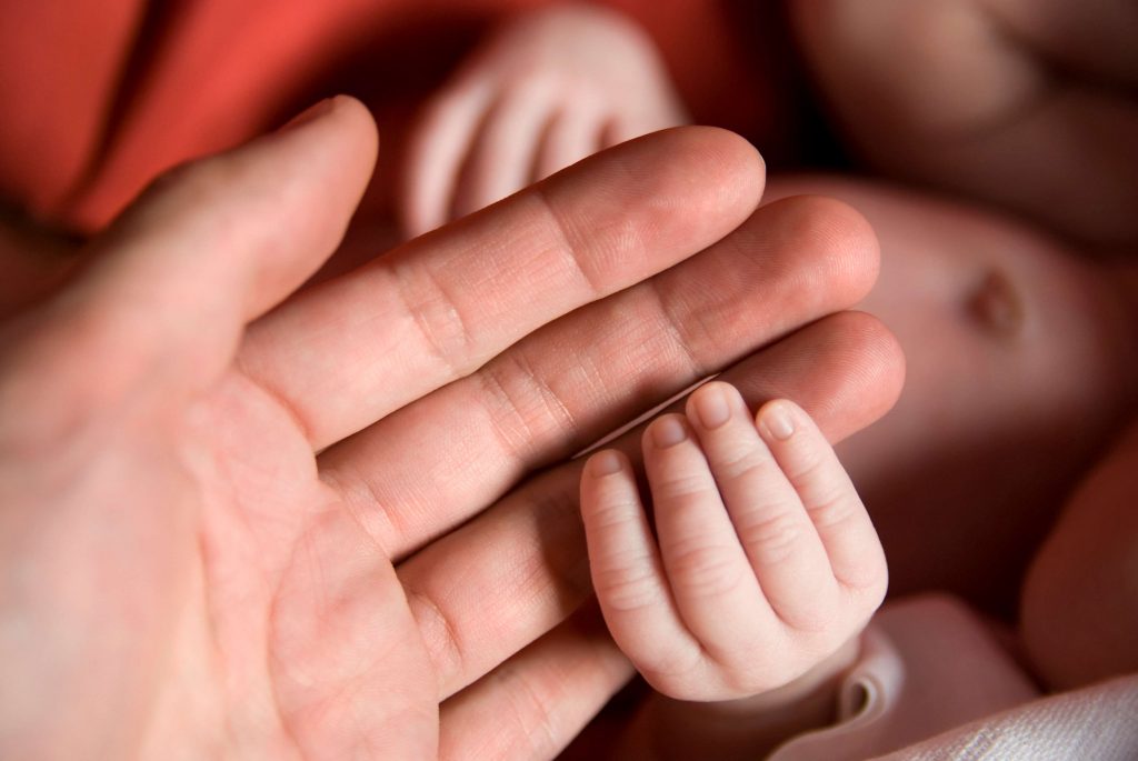 holding newborn's hand