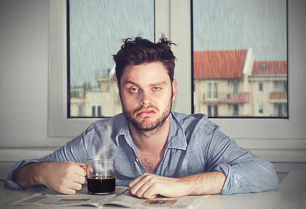 drowsy man drinking coffee