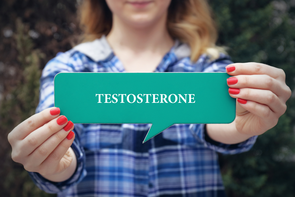 woman holding testosterone sign