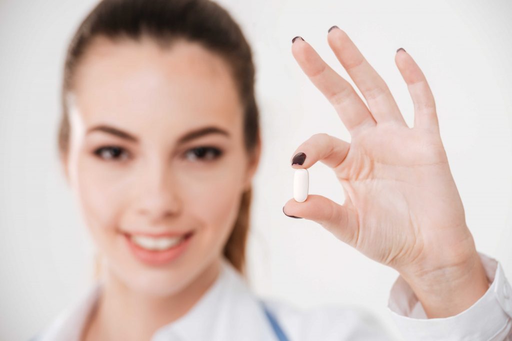 female doctor holding up a pill