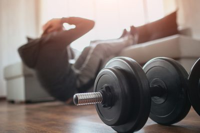 man exercising at home with dumbbells